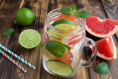 Kahverengi ahşap arka planda greyfurt ve kireç ile Detoks veya infeksiyel su. Closeup.