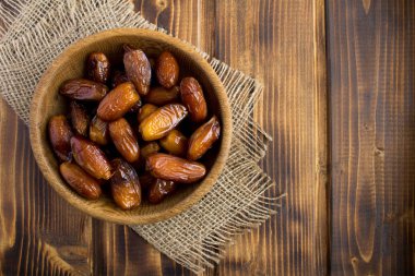 Rustik ahşap arka plan üzerinde kahverengi kase tarihler. Üst te. Kopyalama alanı.