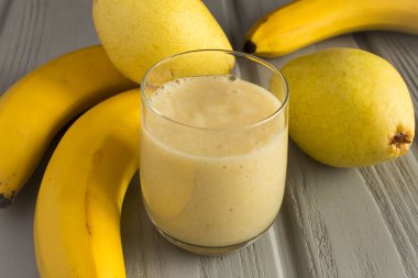 Gri arka planda muz ve armut ile Smoothie