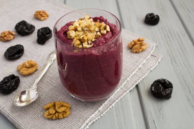 Gri ahşap arka planda pancar, ceviz ve kuru erik ile püre