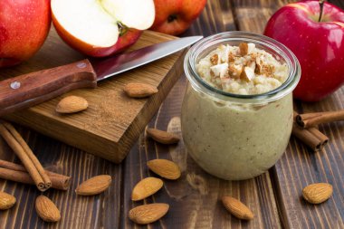 Kırmızı elma, badem, tarçın ve ahşap arka plan üzerinde malzemelerden Smoothies