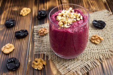 Ahşap rustik arka plan üzerinde pancar, ceviz ve kuru erik ile püre