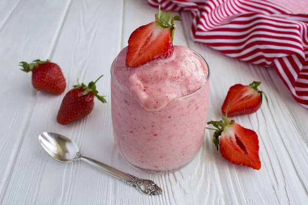 Beyaz ahşap arka plan üzerinde cam çilek ile Smoothies