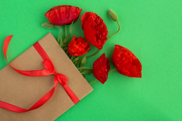 Papoulas Vermelhas Envelope Amarrado Com Uma Fita Vermelha Fundo Verde — Fotografia de Stock