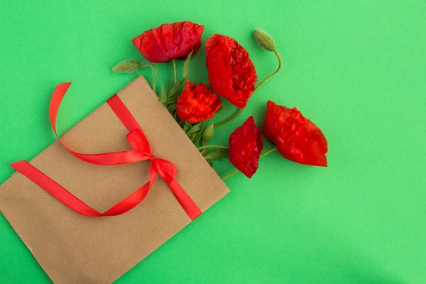 Papoulas Vermelhas Envelope Amarrado Com Uma Fita Vermelha Fundo Verde — Fotografia de Stock