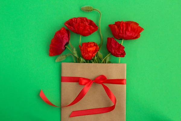 Papoulas Vermelhas Envelope Amarrado Com Uma Fita Vermelha Fundo Verde — Fotografia de Stock