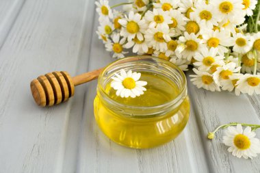 Bal ve papatya gri ahşap arka plan üzerinde