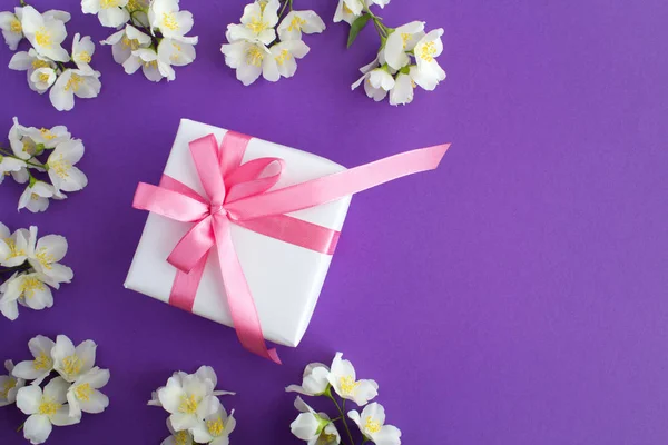 Presente Com Arco Rosa Flores Brancas Jasmim Fundo Violeta Espaço — Fotografia de Stock