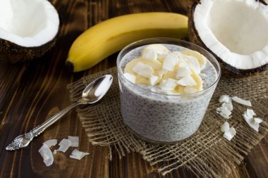 Rustik ahşap arka plan üzerinde hindistan cevizi sütü, chia ve muz ile Puding