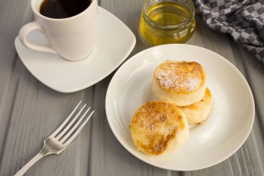 Kahvaltı: gri ahşap arka plan üzerinde peynir krep, kahve ve bal