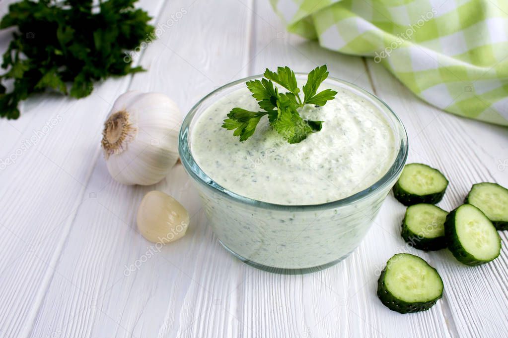 Traditional greek yogurt with cucumber on the white  wooden background.Closeup.