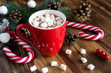 Ahşap arka plan üzerinde kırmızı fincan marshmallows ile sıcak çikolata