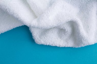 Mavi arka planda beyaz havlu. Üst te. Kopya alanı. Closeup.