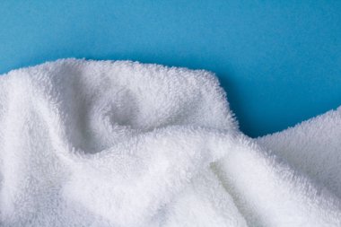 Mavi arka planda beyaz havlu. Üst te. Kopya alanı. Closeup.