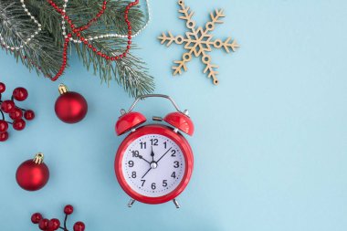 Mavi arka planda kırmızı çalar saat ile Noel kompozisyon. Üst te. Kopyalama alanı.