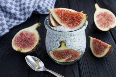 Siyah ahşap arka plan üzerinde chia ve incir ile puding. Closeup.
