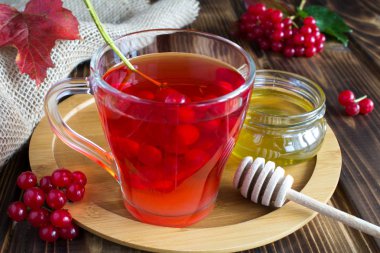 Rustik arka planda viburnum ve bal ile çay