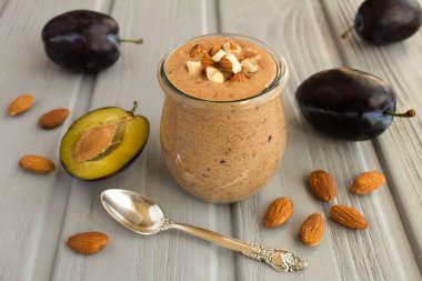 Gri ahşap arka plan üzerinde taze erik ve badem ile Yoğurt smoothies