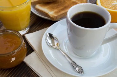 Kahvaltı: ahşap arka planda kahve, tost, meyve suyu ve reçel
