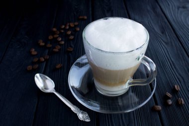 Siyah ahşap arka plan üzerinde cam fincan kahve latte. Closeup.