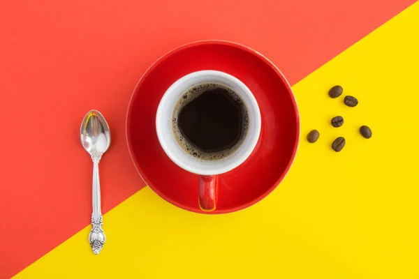 Black coffee in the red cup in the center of the colorful background. Copy space. Top view.