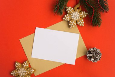 Kırmızı arka plan üzerinde metin, zarf ve noel kompozisyonu için boş beyaz kağıt. Üst te. Kopyalama alanı.