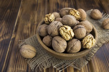 Kırsal ahşap arka planda kahverengi kasede cevizler. Yakın çekim..