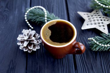 Kahverengi seramik fincanda sade kahve ve koyu ahşap arka planda Noel kompozisyonu. Yakın çekim..