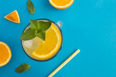 Mavi arka planda naneli ve buzlu portakal suyu veya limonata. Üst Manzara. Boşluğu kopyala.