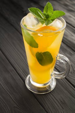 Portakal suyu ya da siyah ahşap arka planda naneli ve buzlu limonata. - Yakın çekim. Konum dikey.