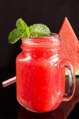 Siyah arkaplandaki karpuzun meyveli içeceklerine yakın çekim. Konum dikey.