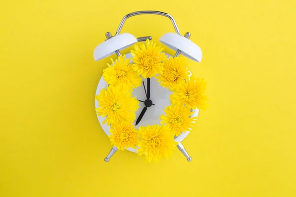 Sarı Yüzey Merkezindeki Beyaz Alarm Saatinin Kadranında Sarı Çiçekler Var — Stok fotoğraf
