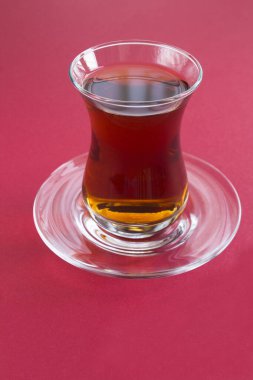Kırmızı arkaplanda bardakta Türk çayı
