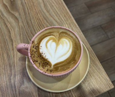 Masadaki pembe fincanda kapuçino kahvesi. Yakın plan. Üst görünüm.