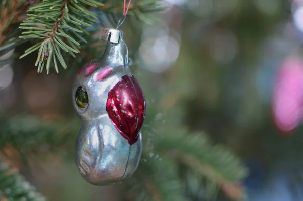 Vintage Christmas toys on a festive tree. Parrot