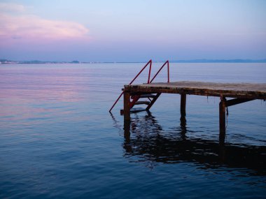 Gün batımında, Durres, Arnavutluk denizde ahşap bir iskele yan görünüm. Muhteşem günbatımı gökyüzü