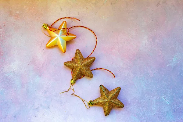 Christmas composition. Christmas stars, golden decorations on light pink background. Flat lay, top view, copy space