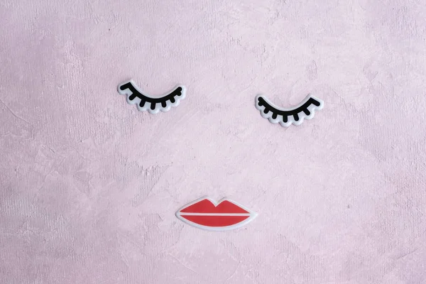 Cara creativa de mujer hecha de pestañas y labios. Concepto de belleza mínima. Fondo rosa, plano de moda. banner — Foto de Stock