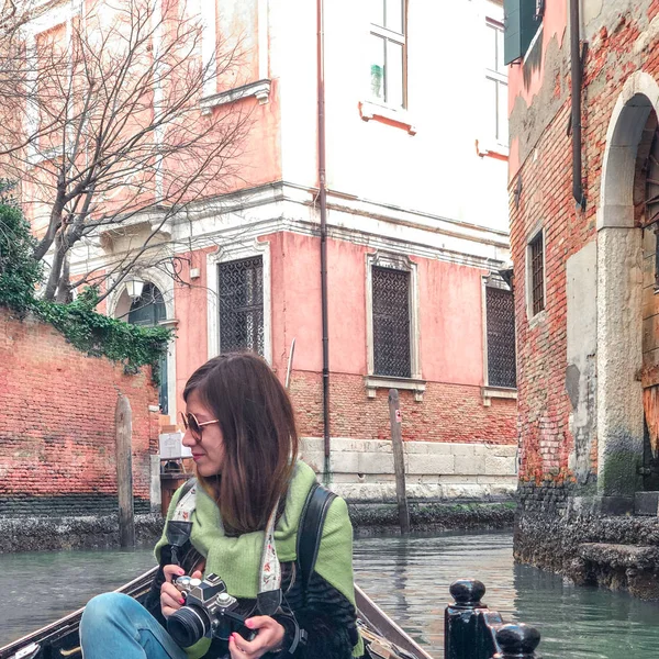 Une jeune femme profite d'une balade en gondole et de faire des photos dans les canaux de Venise . — Photo