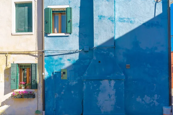 stock image Close up of bright blue painted stucco and brick wall on Burano Island near Venice, Italy. Background texture.