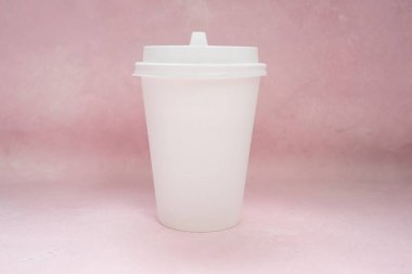 Kahve ambalaj mockup - kopya alanı ile açık pembe arka plan üzerinde beyaz kapak lı beyaz kağıt fincan