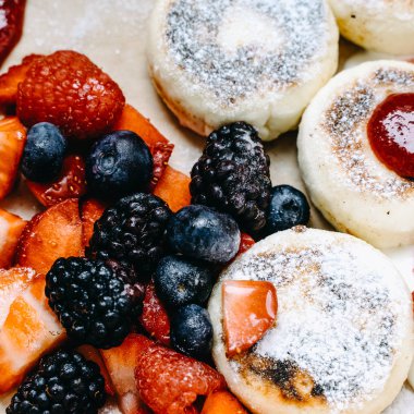 Taze ahududu, yaban mersini, çilek, sos ve şeker, seçici odak, kare ile hizmet veren ev yapımı krep