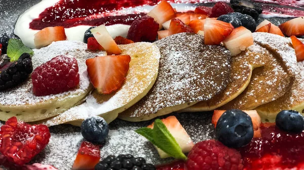 Taze ahududu, yaban mersini, çilek, sos ve şeker, seçici odak, afiş ile hizmet veren ev yapımı krep