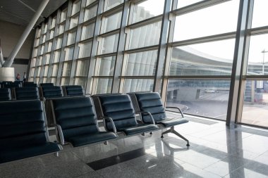 Havaalanı terminalinde uçuş bekleyen yolcular için boş sandalyeler, banklar, seçilmiş odak
