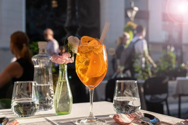 Skleněná Sklenička z Aperolů na stole v pouliční restauraci, slavný osvěžující nápoj za slunečného dne Royalty Free Stock Obrázky
