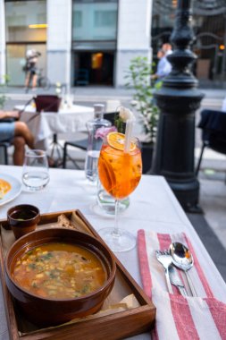 Aperol Spritz kokteyl, su ve ünlü Macar çorbası gulyas bardak sokak restoranında masada, güneşli bir günde
