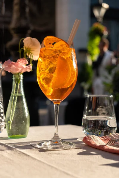 Copa de Aperol Spritz cóctel en la mesa en el restaurante de la calle, famosa bebida refrescante en el día soleado Imagen de stock