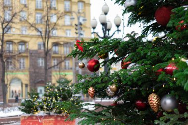 Işıklı, kar taneli ve süslemeli Noel ağacına yakın çekim. Noel ve Yeni Yıl tatili geçmişi