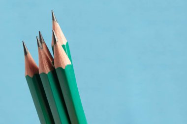 Beş grafit kalem yeşil renk ahşap kabuk ile mavi arka plan üzerinde ayarlayın..