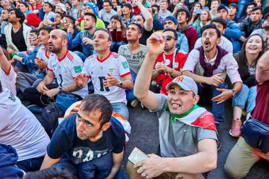 St. Petersburg, Rusya Federasyonu - 25 Haziran 2018: İran hayranları takım İran ve Portekiz, futbol maçı sırasında büyük ekranının önünde asfalt üzerinde oturuyorsun ve duygusal destek onların ekibi.